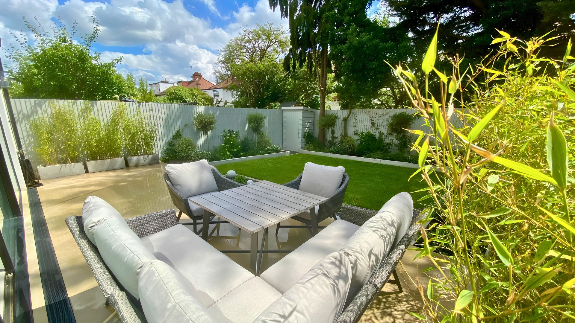 Modern garden patio with rattan dining set, low maintenance lawn, Wembley garden design